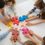 teacher and preschoolers putting together a puzzle
