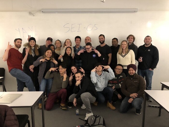 Group posing by whiteboard