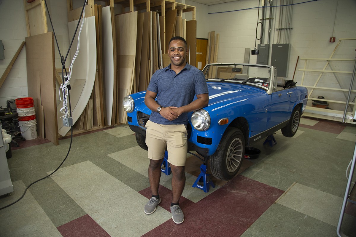 Tiree Walker stands in front of the MG Midget car he is working on for a 3D scanning research project.